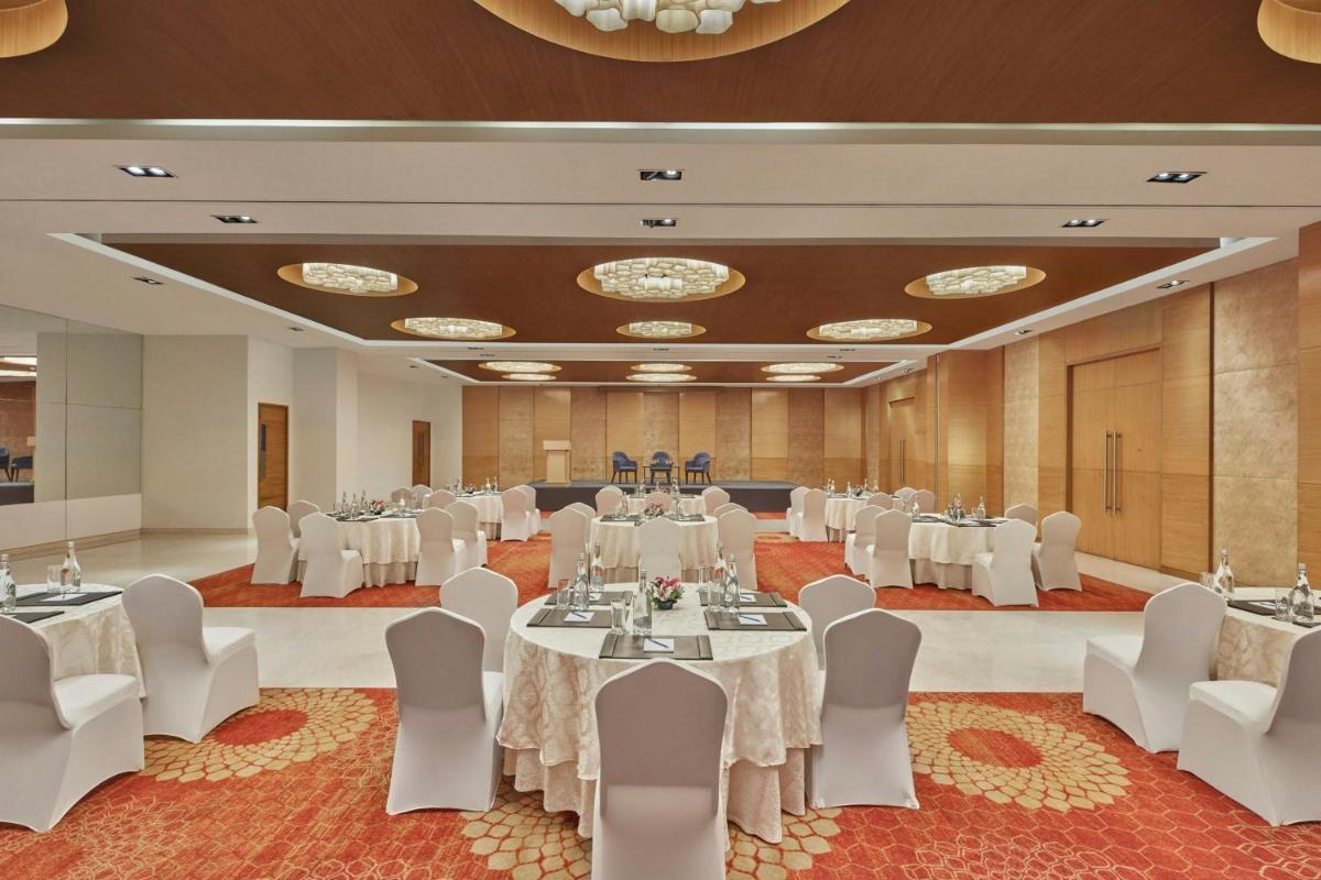 a banquet hall with white tables and chairs at Four Points by Sheraton Hotel and Serviced Apartments Pune in Pune