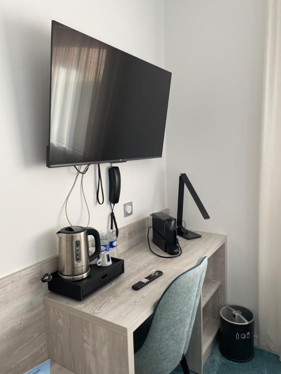 Télévision ou salle de divertissement dans l'établissement Hôtel Le Manoir du Roselier