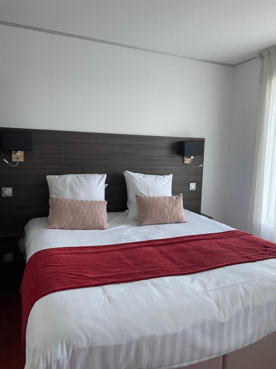 Un ou plusieurs lits dans un hébergement de l'établissement Hôtel Le Manoir du Roselier