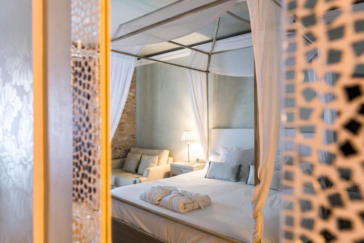 Un dormitorio con una cama blanca con dosel. en Hotel Sa Calma, en Begur