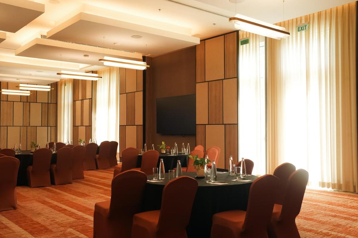 a conference room with tables and chairs and a screen at Hyatt Place Gurgaon Udyog Vihar in Gurgaon
