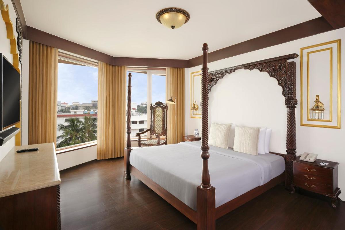 a bedroom with a bed and a large window at Novotel Mumbai Juhu Beach in Mumbai