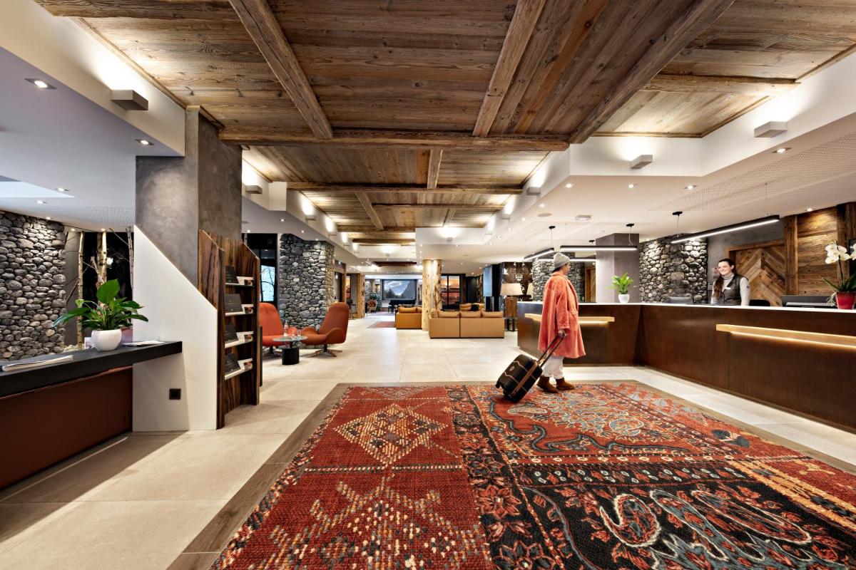 un hall d'entrée avec un tapis au sol dans l'établissement MGM Hôtels & Résidences - Hôtel Les Suites d'Alexane, à Samoëns