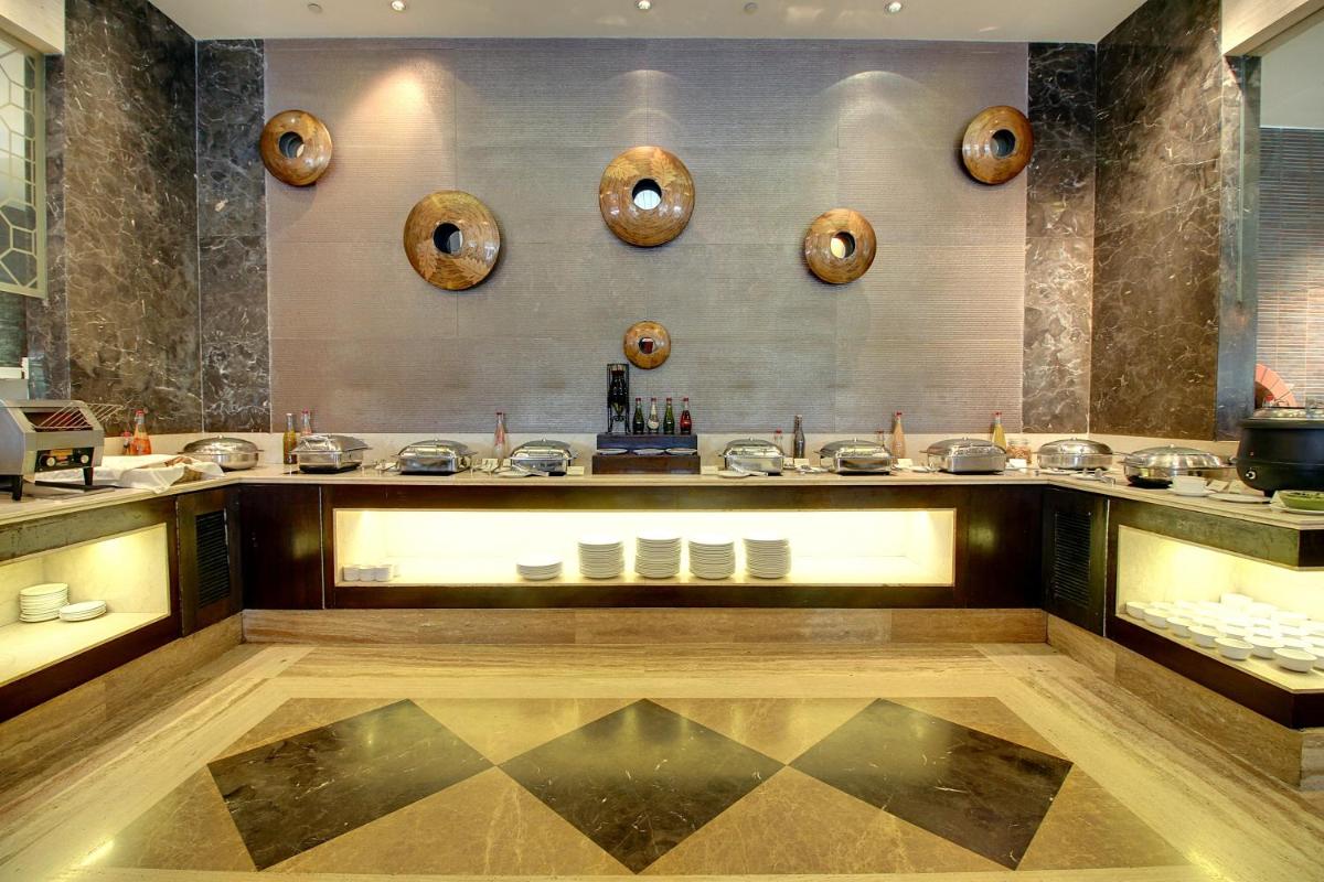 a room with a counter with bowls and mirrors at The Pllazio Hotel in Gurgaon