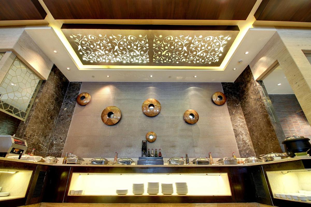 a restaurant with a counter with a bunch of sinks at The Pllazio Hotel in Gurgaon