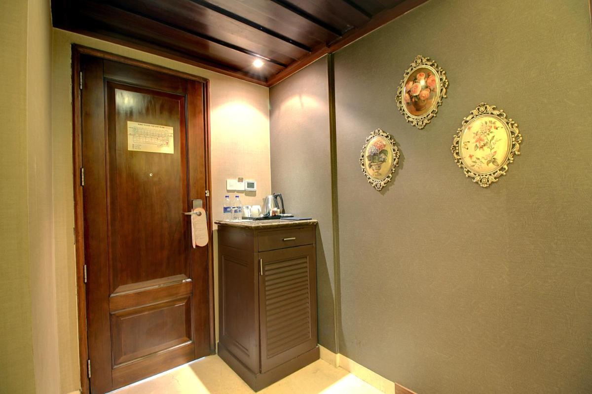a hallway with a door and plates on the wall at The Pllazio Hotel in Gurgaon