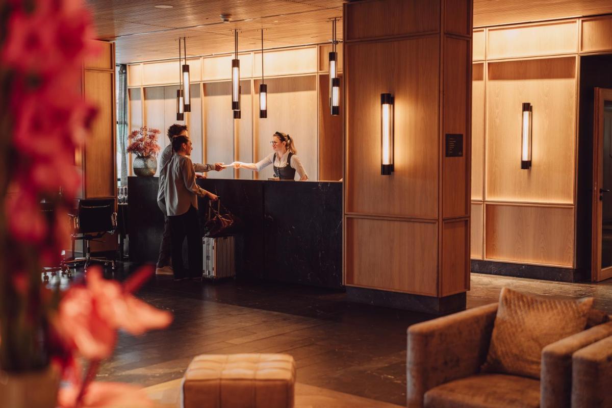 Zwei Frauen stehen an einem Tresen in einer Lobby in der Unterkunft Parkhotel Egerner Höfe in Rottach-Egern + 112 Fotos