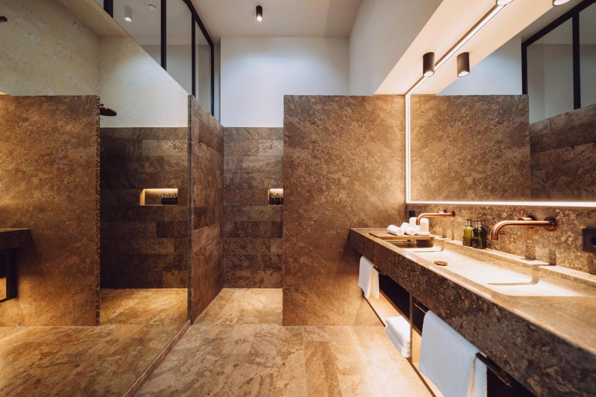 ein Badezimmer mit zwei Waschbecken und einer Dusche in der Unterkunft Parkhotel Egerner Höfe in Rottach-Egern