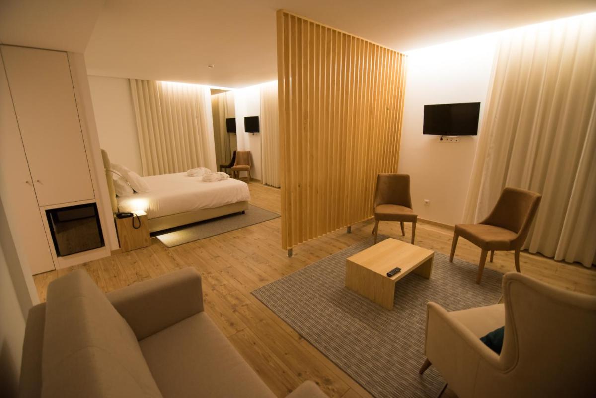 uma sala de estar com um sofá e uma cama em LAM Hotel Celorico de Basto em Celorico de Basto