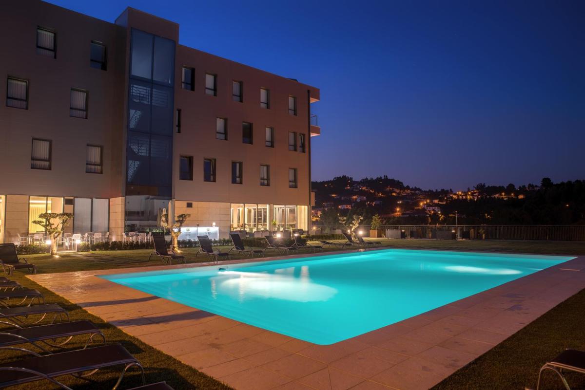 uma piscina em frente a um prédio à noite em LAM Hotel Celorico de Basto em Celorico de Basto