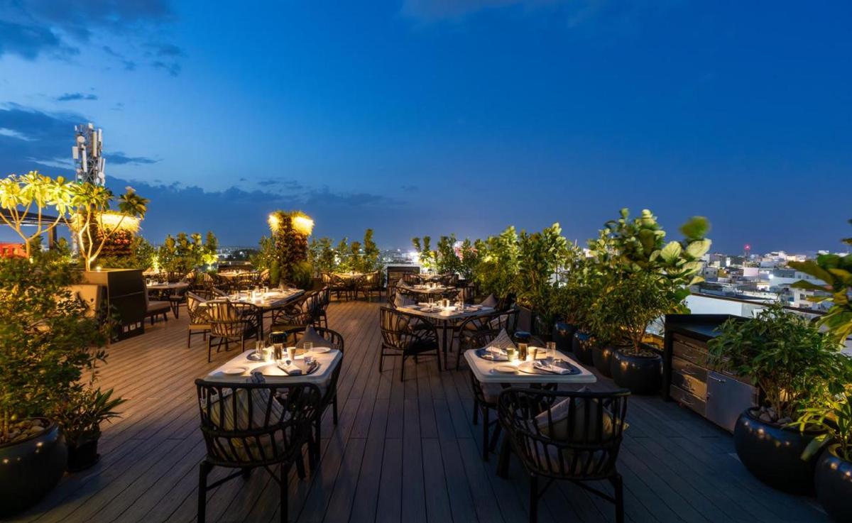 a restaurant with tables and chairs on a deck at night at The Residency Towers Puducherry in Puducherry
