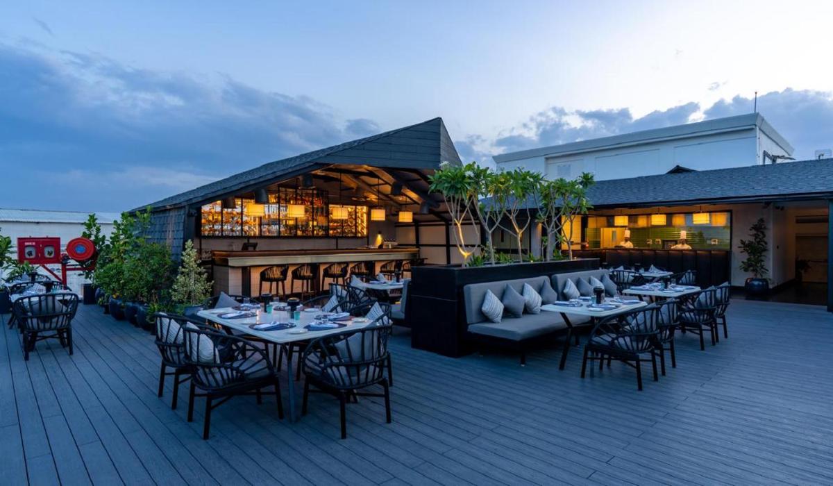 a restaurant with tables and chairs on a patio at The Residency Towers Puducherry in Puducherry