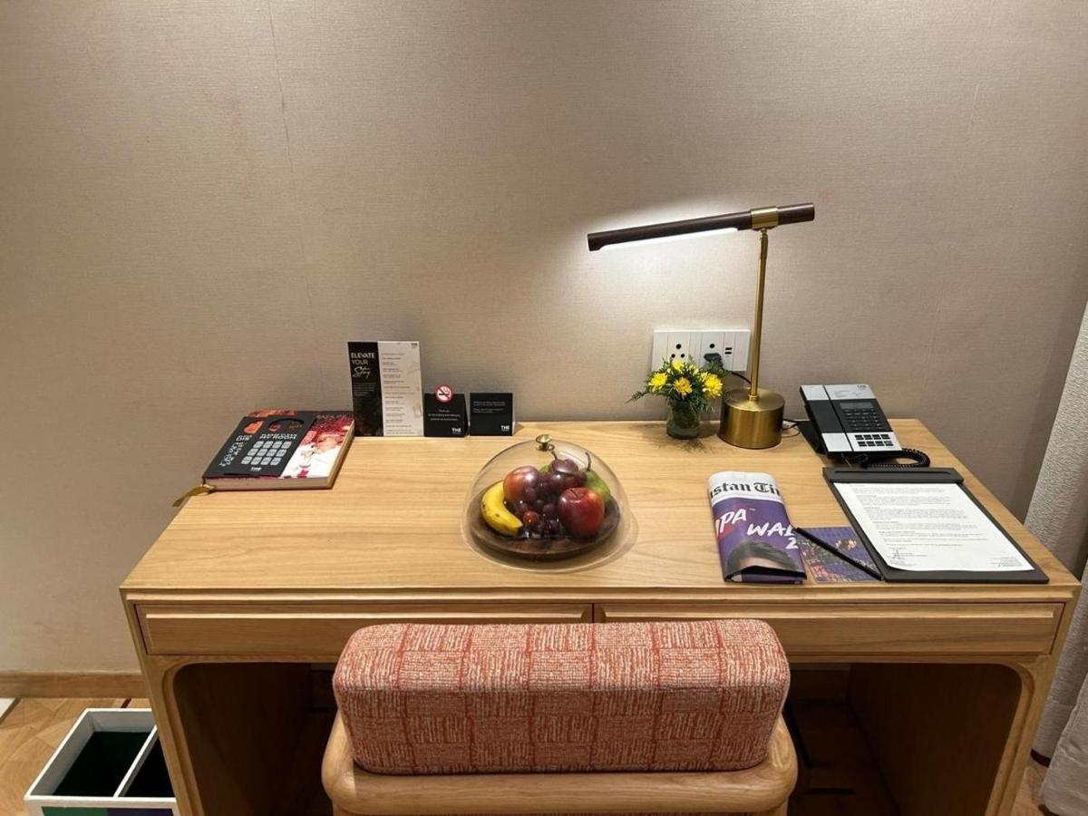 a wooden desk with a bowl of fruit on it at The Park New Delhi in New Delhi