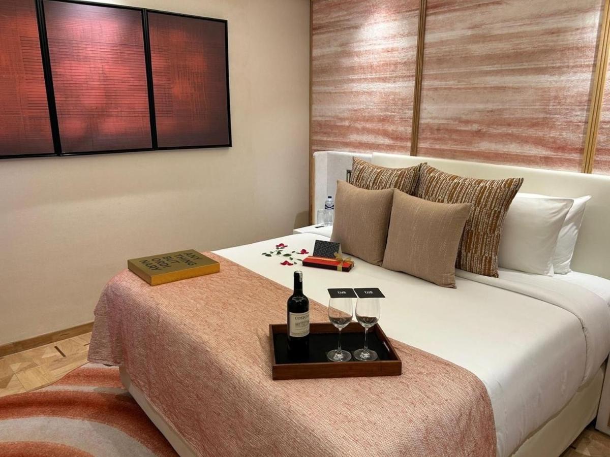 a bed with a tray with a bottle of wine on it at The Park New Delhi in New Delhi
