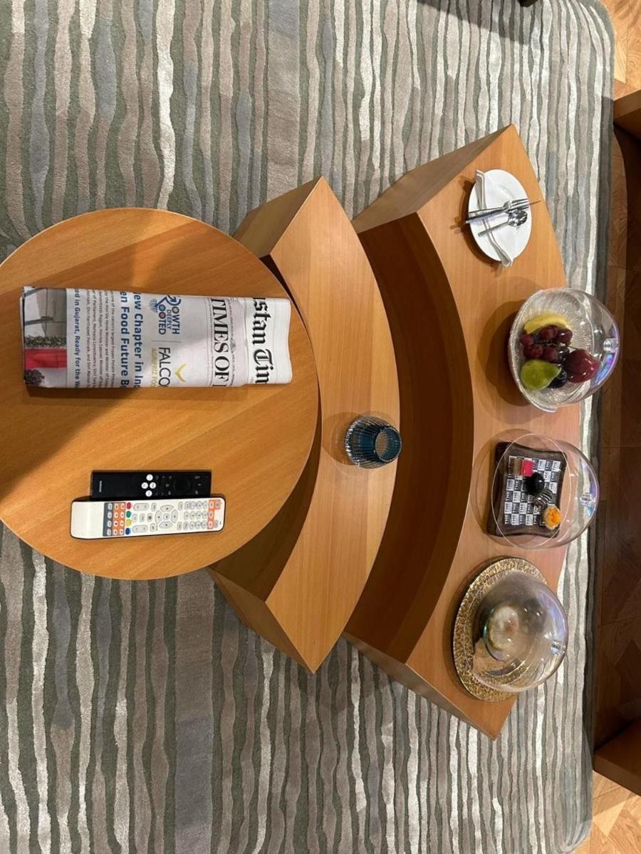 a wooden book shelf with food and drinks on it at The Park New Delhi in New Delhi