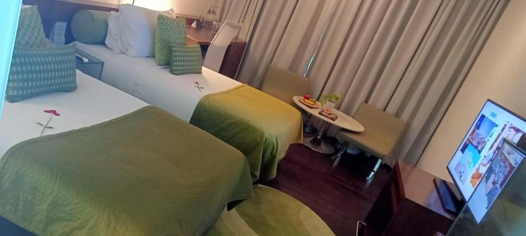 a hotel room with two beds and a flat screen tv at The Park New Delhi in New Delhi