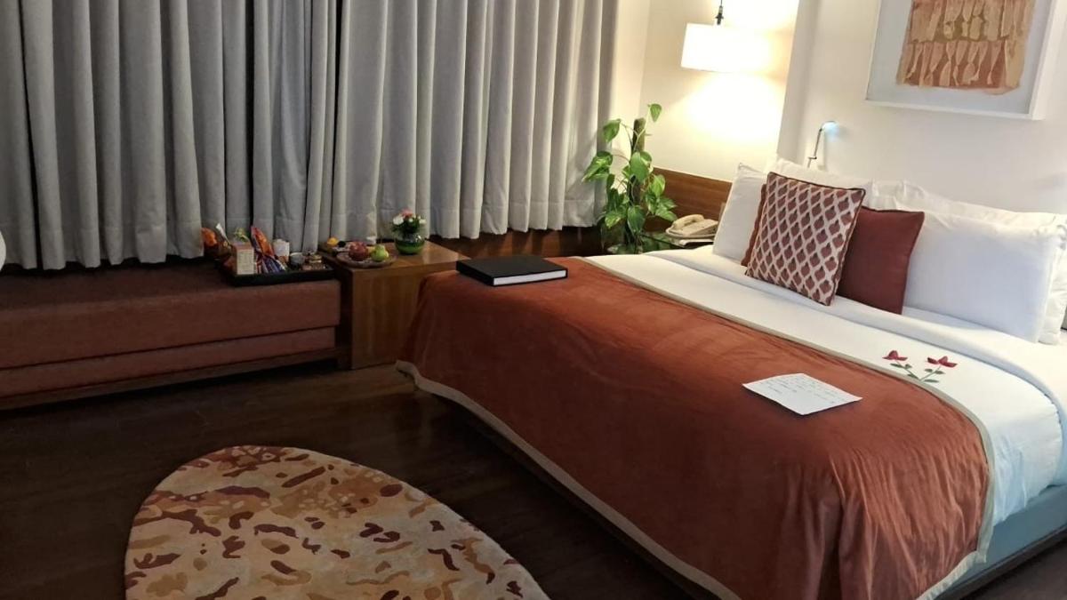 a bedroom with a large bed with a book on it at The Park New Delhi in New Delhi