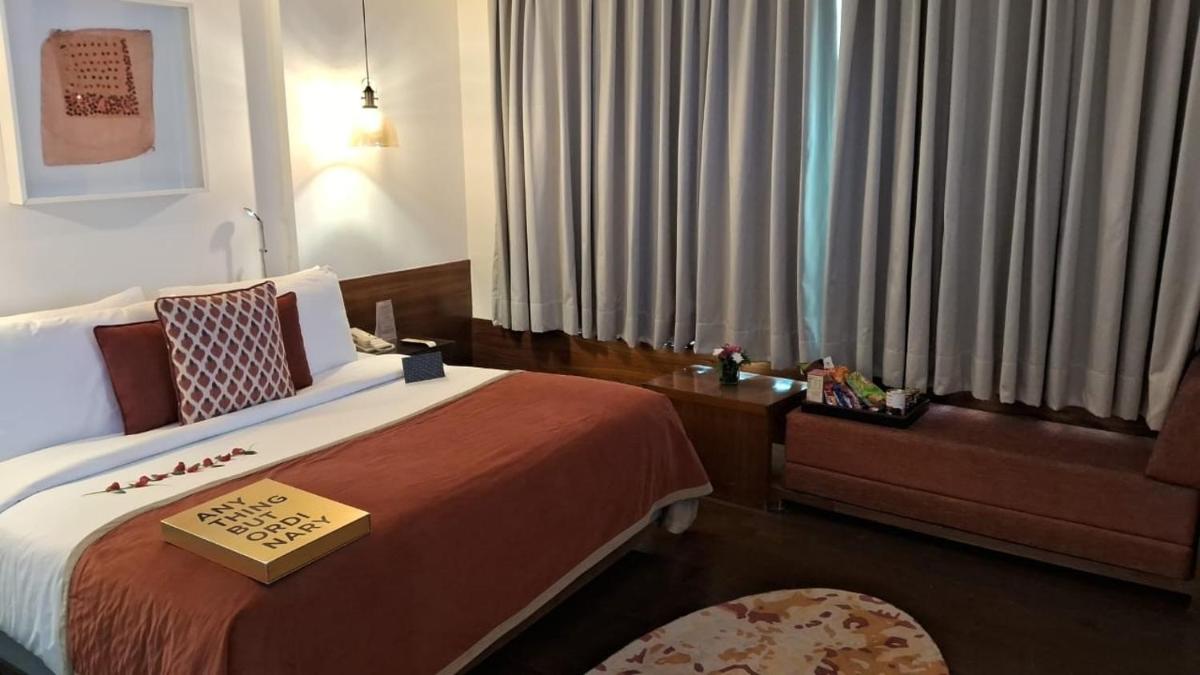 a hotel room with a bed with a book on it at The Park New Delhi in New Delhi