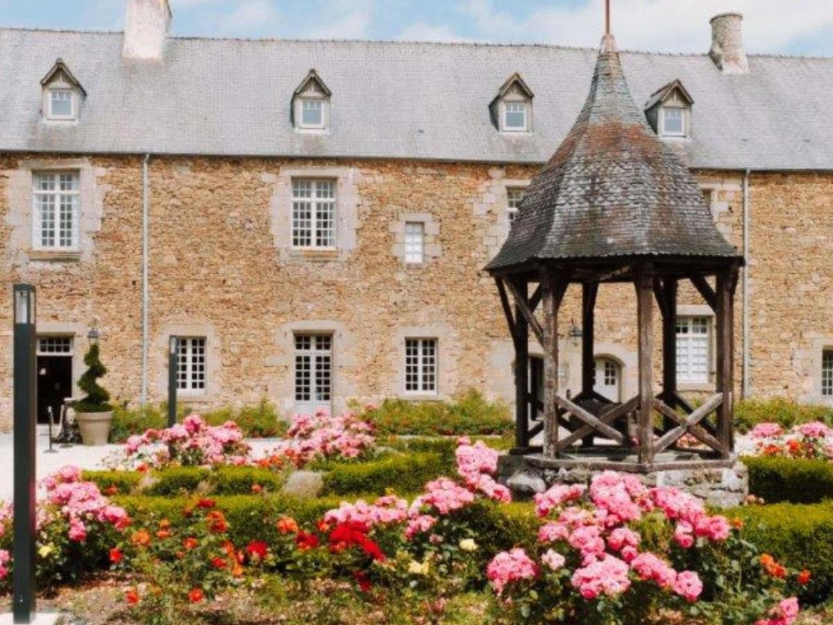 un kiosque à fleurs devant un bâtiment dans l'établissement Hotel de L'Abbaye Le Tronchet - Handwritten Collection, au Tronchet