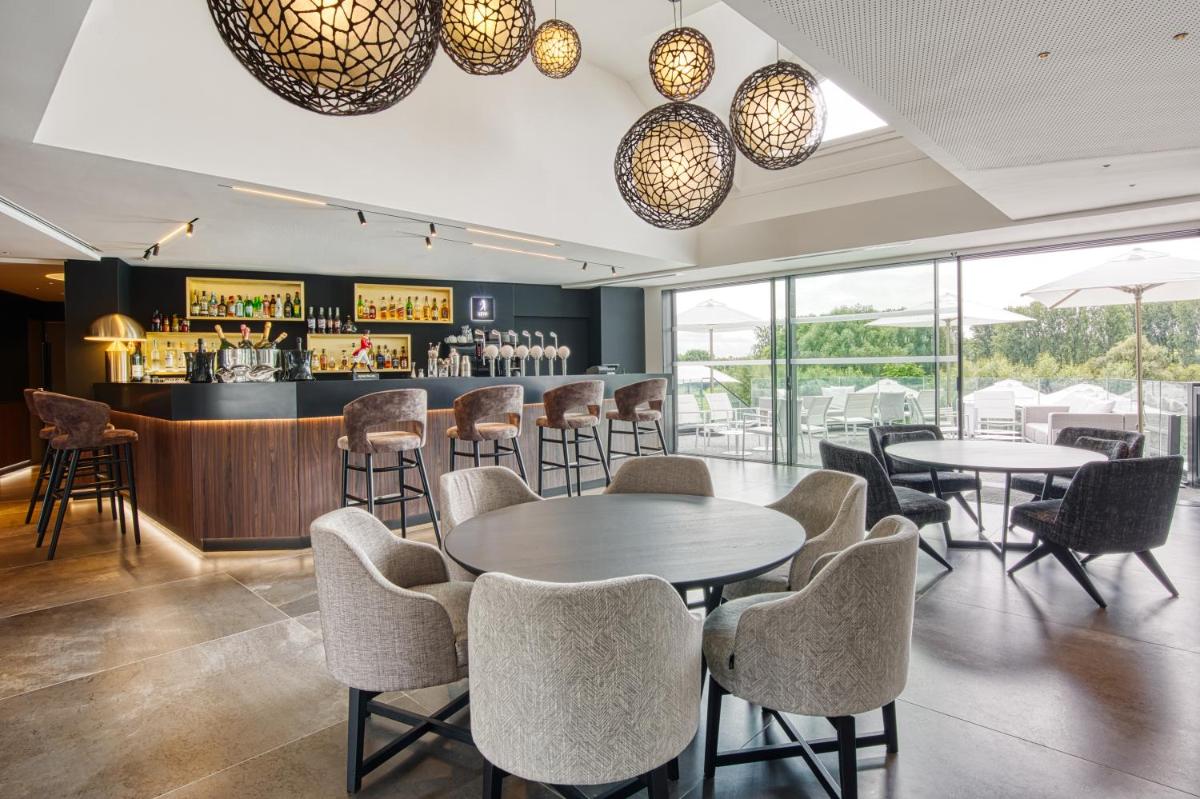 un restaurant avec des tables et des chaises et un bar dans l'établissement Best Western Plus Le Fairway Hotel & Spa Golf d'Arras, à Anzin-Saint-Aubin