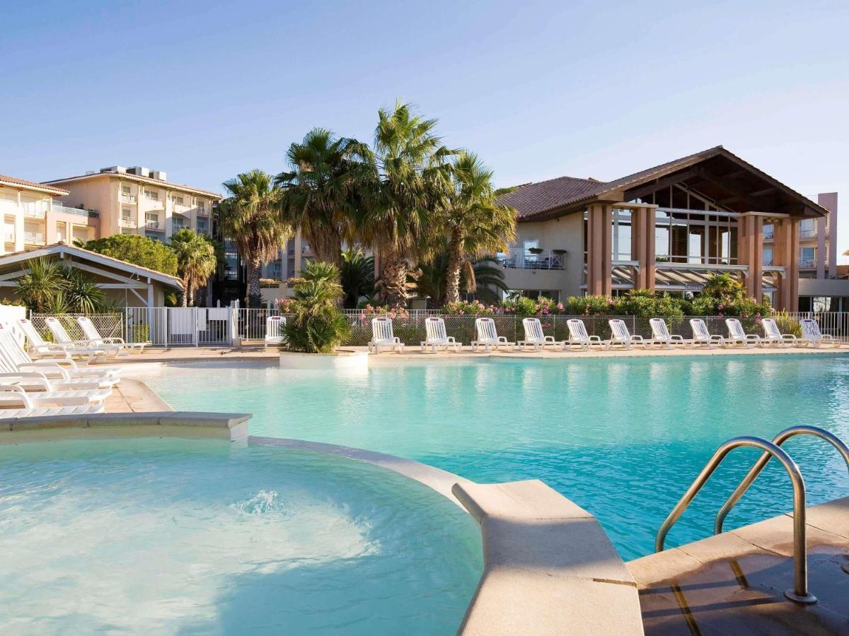 une grande piscine avec chaises longues et appartements dans l'établissement Mercure Thalasso & Spa Port Fréjus, à Fréjus