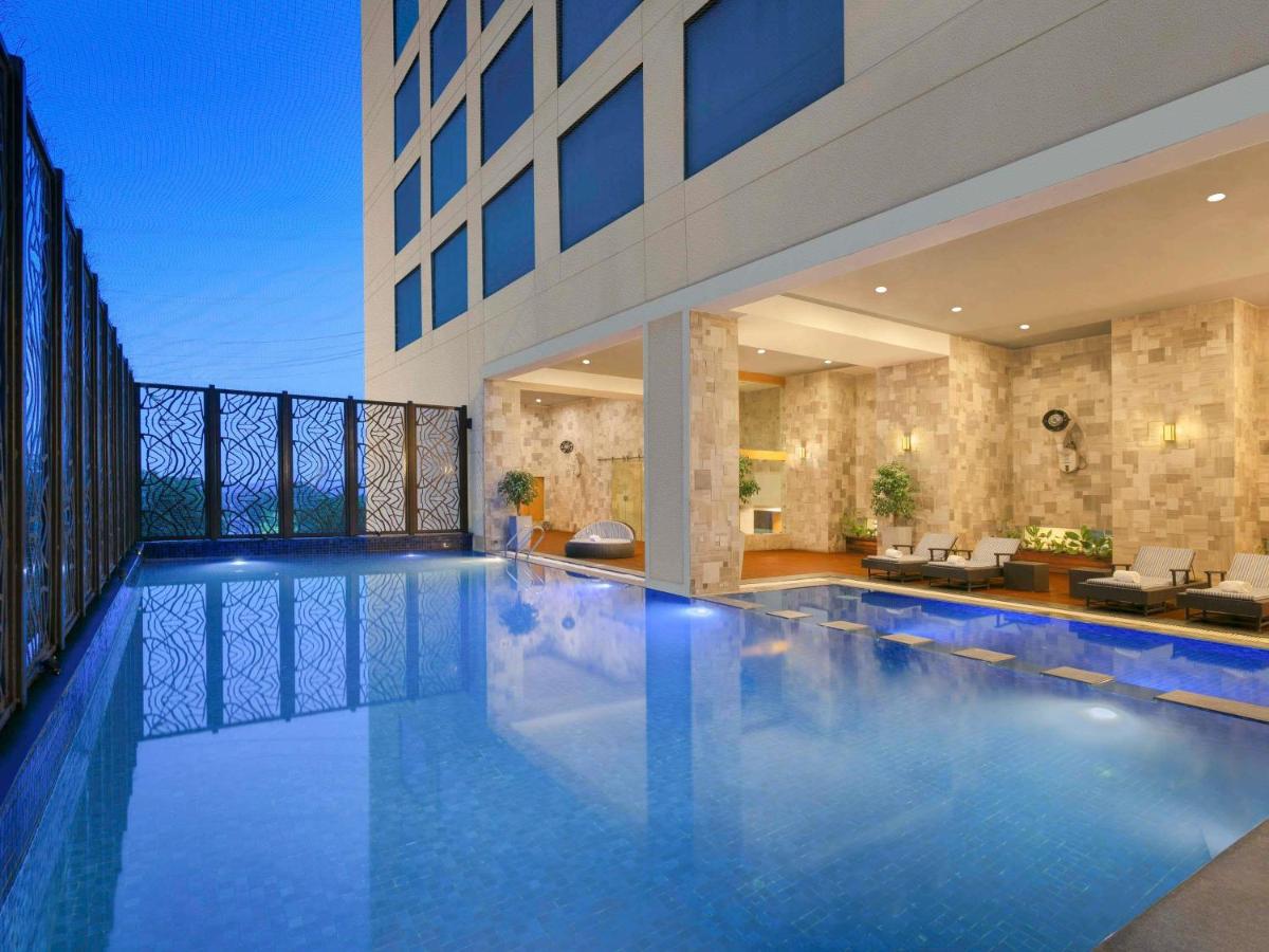 a large swimming pool in a building at Novotel Ahmedabad in Ahmedabad