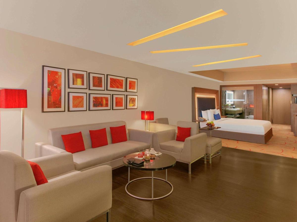 a living room with a couch and a bed at Novotel Ahmedabad in Ahmedabad