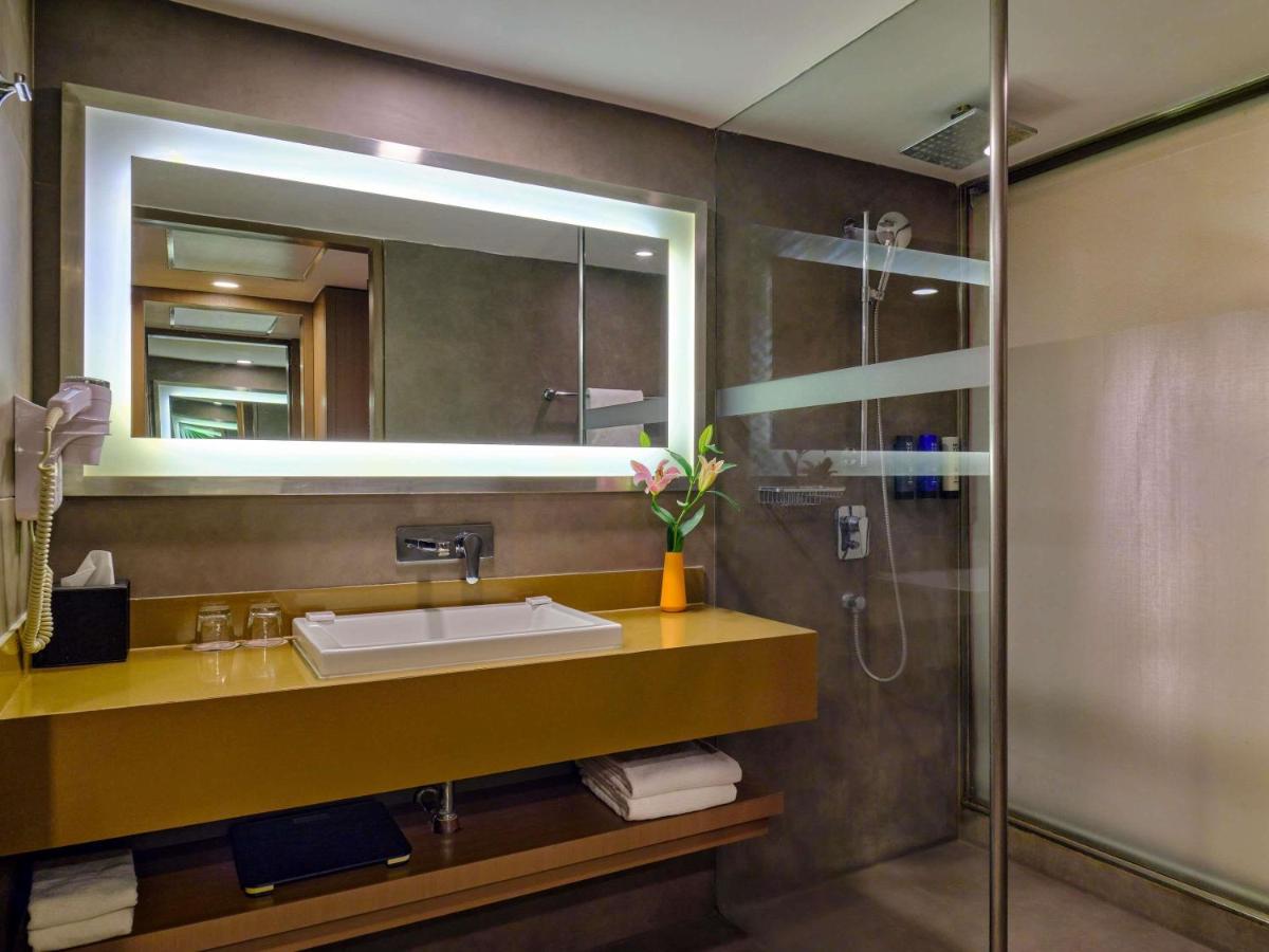a bathroom with a sink and a mirror at Novotel Ahmedabad in Ahmedabad