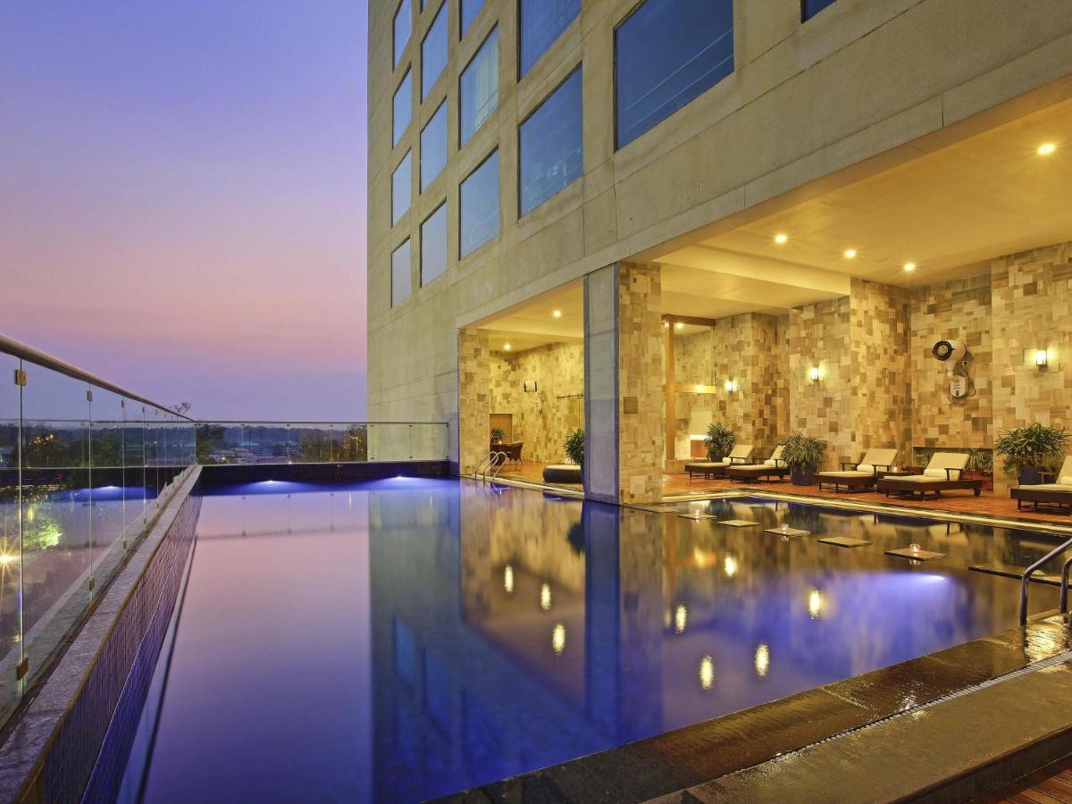 a swimming pool in the middle of a building at Novotel Ahmedabad in Ahmedabad