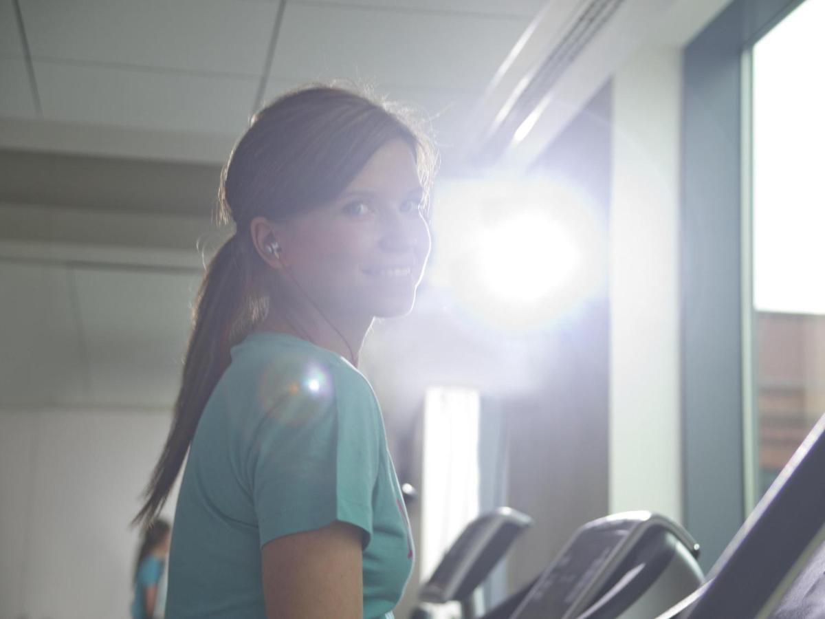 a young girl is running on treadmills in a gym at Novotel Ahmedabad in Ahmedabad