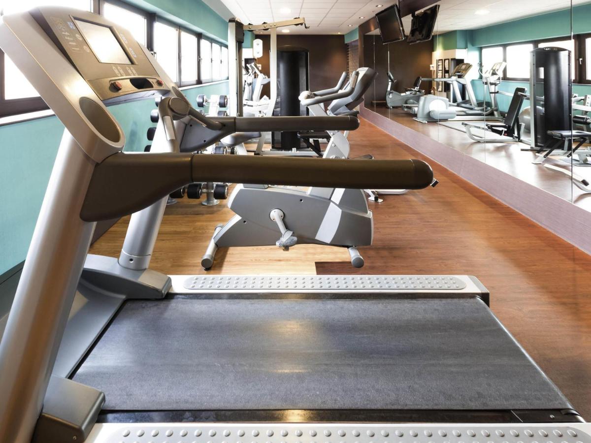 a gym with treadmills and ellipticals at Novotel Ahmedabad in Ahmedabad