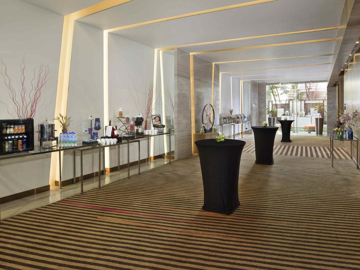 a lobby with a row of black vases on the floor at Novotel Ahmedabad in Ahmedabad
