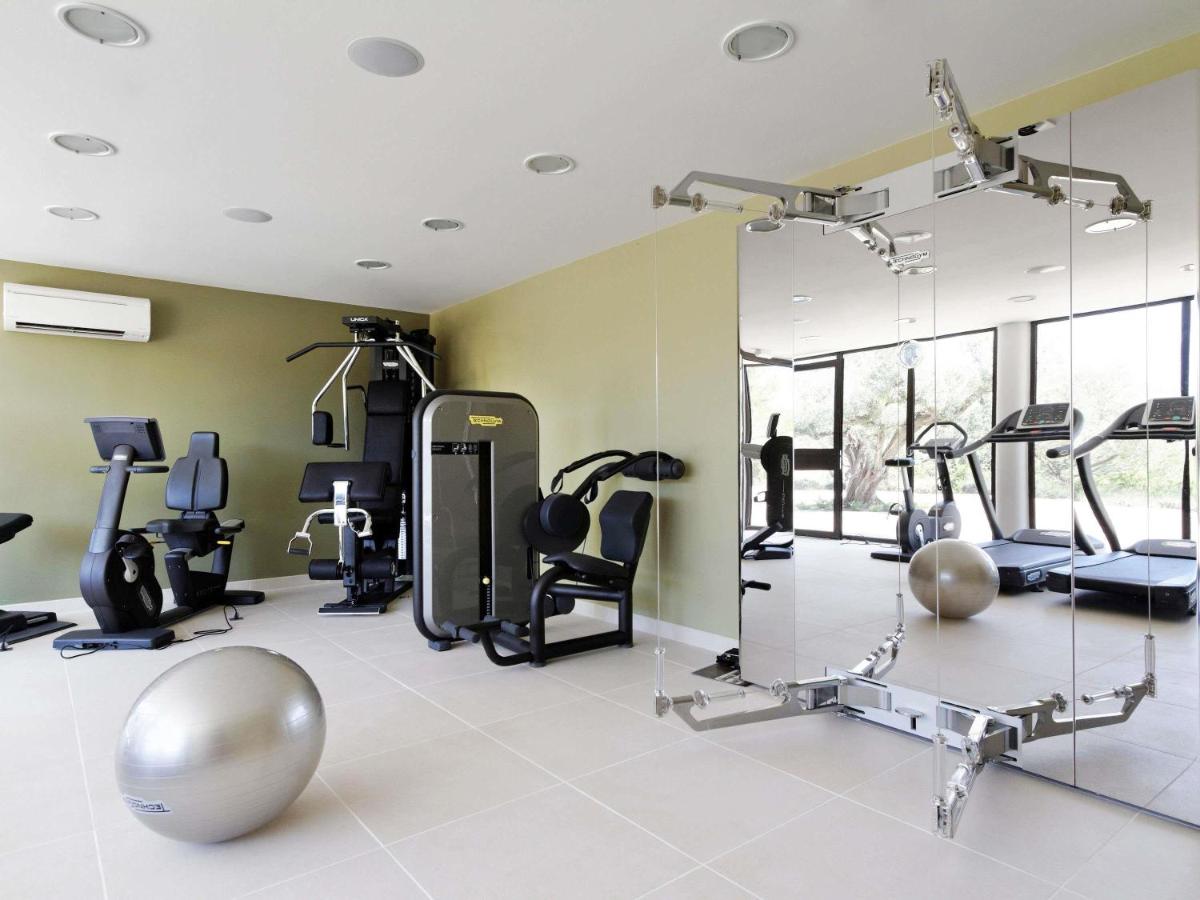 une salle de sport avec un miroir et des appareils d'exercice dans l'établissement Mercure Brignoles Golf de Barbaroux & Spa, à Brignoles