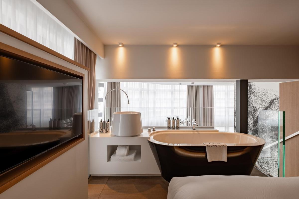 une salle de bains avec baignoire et lavabo dans l'établissement Le Cinq Codet, à Paris une salle de bains avec baignoire et lavabo dans l'établissement Le Cinq Codet, à Paris