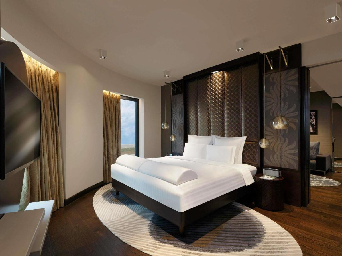 a bedroom with a large bed and a large window at Pullman New Delhi Aerocity in New Delhi