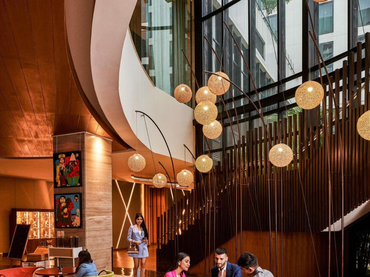 a group of people sitting in a lobby with lights at Pullman New Delhi Aerocity in New Delhi