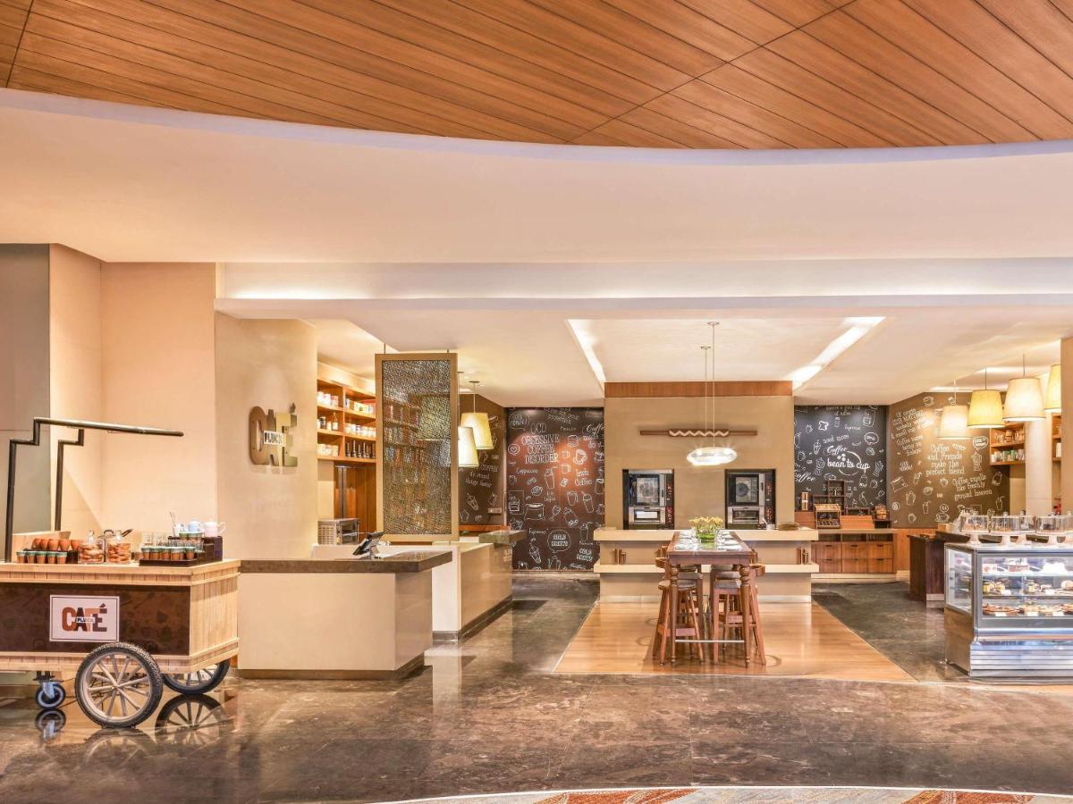 a lobby of a hotel with a table and chairs at Pullman New Delhi Aerocity in New Delhi