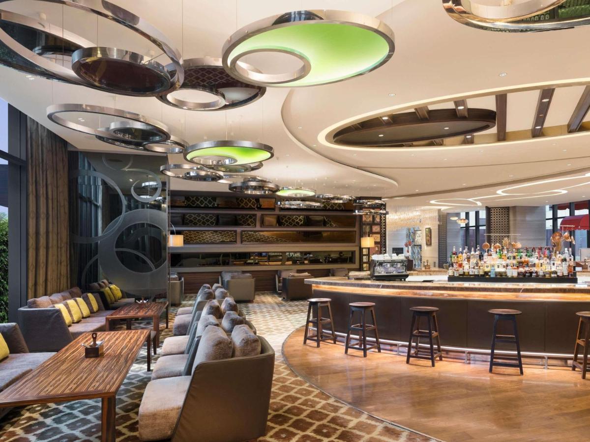 a bar at a hotel with couches and a counter at Pullman New Delhi Aerocity in New Delhi