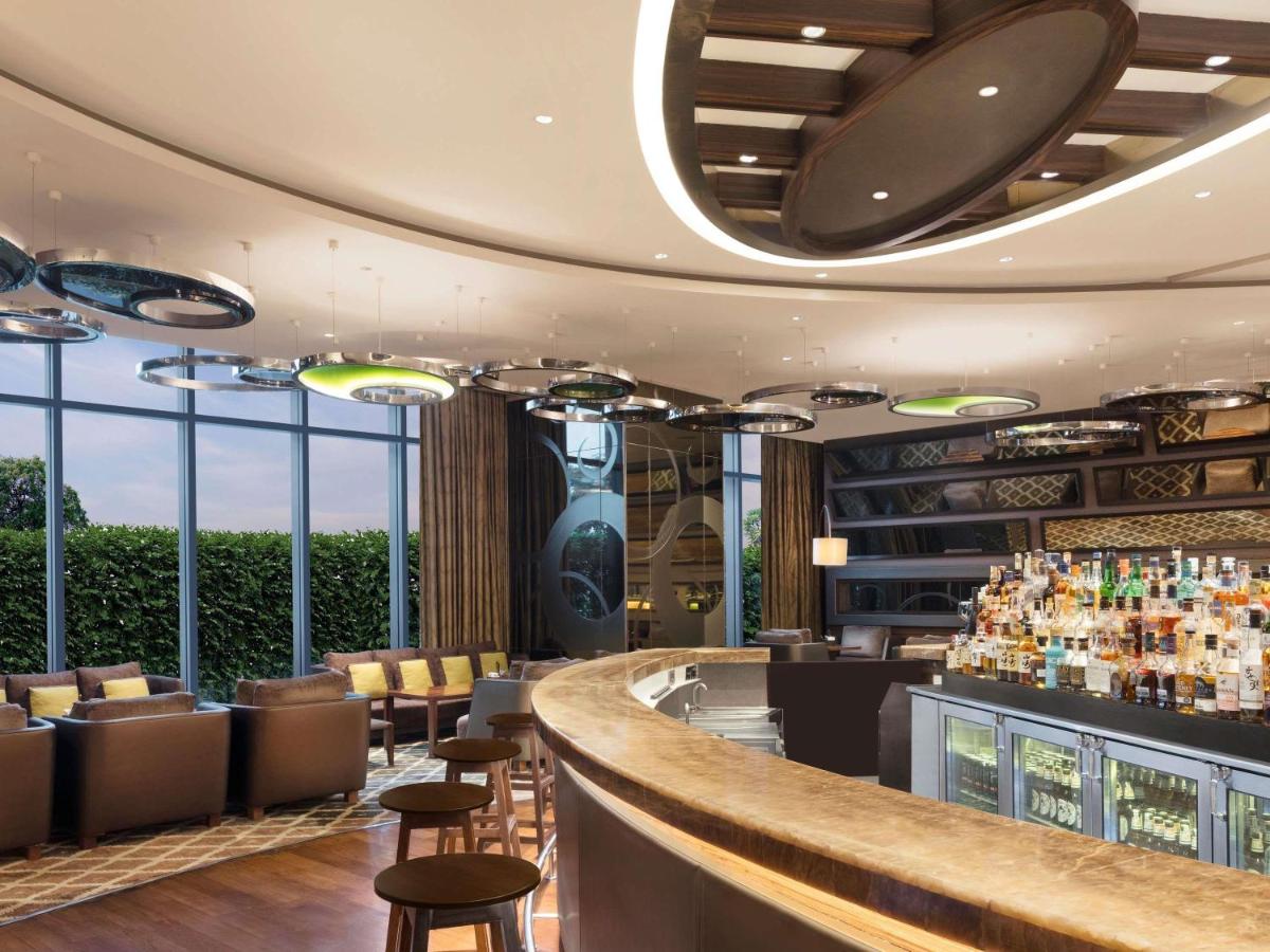 a bar at a hotel with chairs and a counter at Pullman New Delhi Aerocity in New Delhi