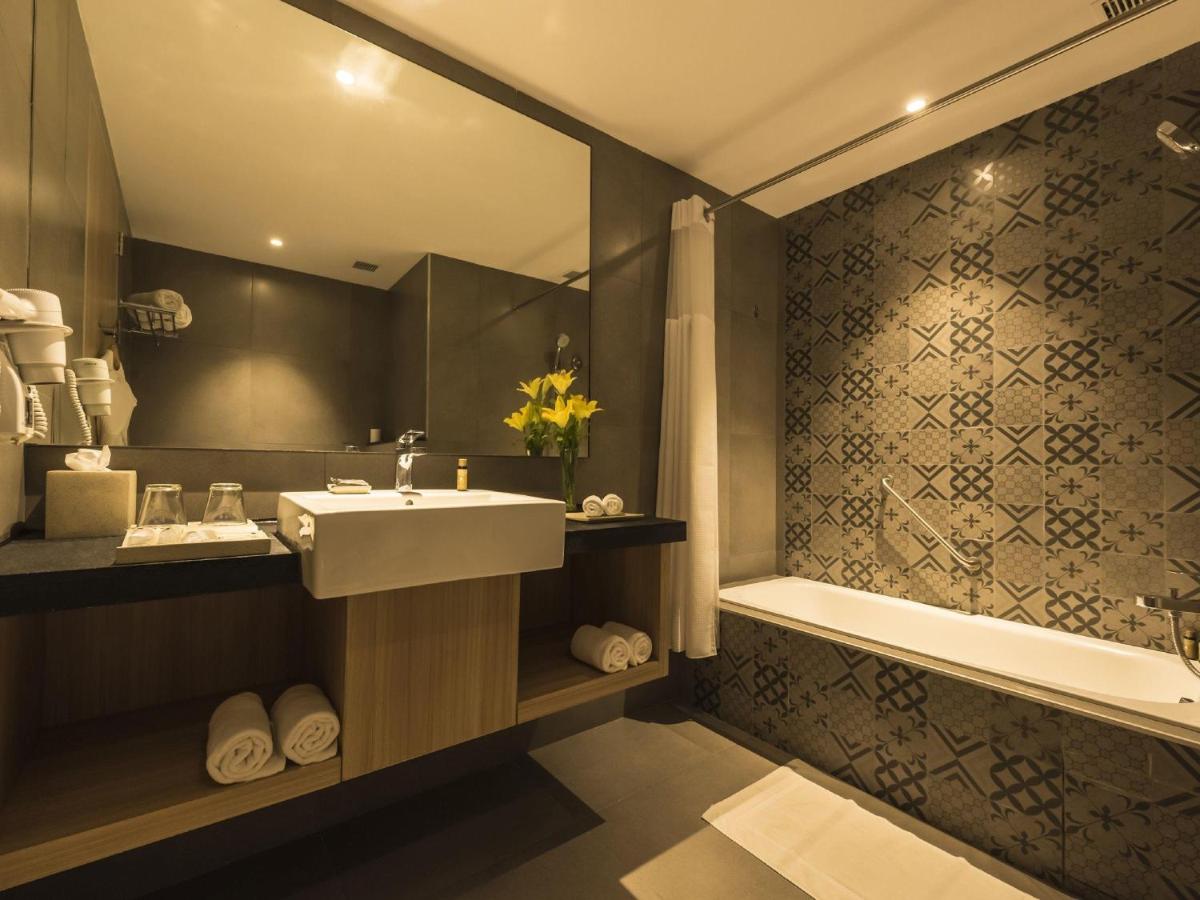 a bathroom with a sink and a bath tub at Grand Mercure Mysore - An Accor Brand in Mysore