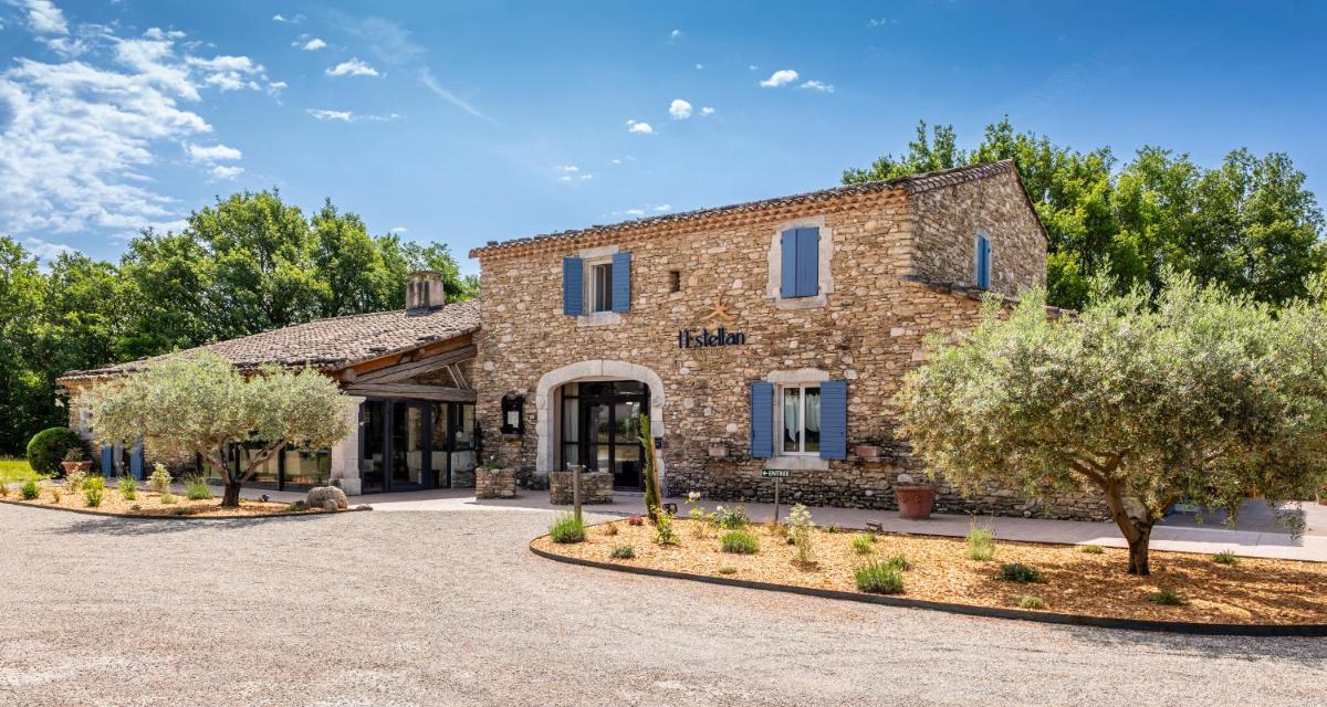 un bâtiment en pierre avec des arbres devant dans l'établissement Mas De La Senancole & Spa, à Gordes