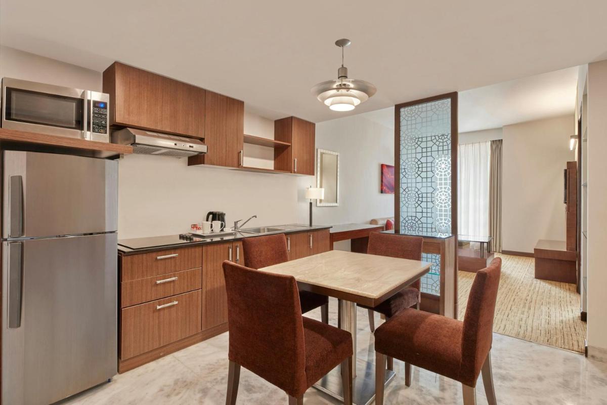 a kitchen and dining room with a table and chairs at Four Points by Sheraton Hotel and Serviced Apartments Pune in Pune