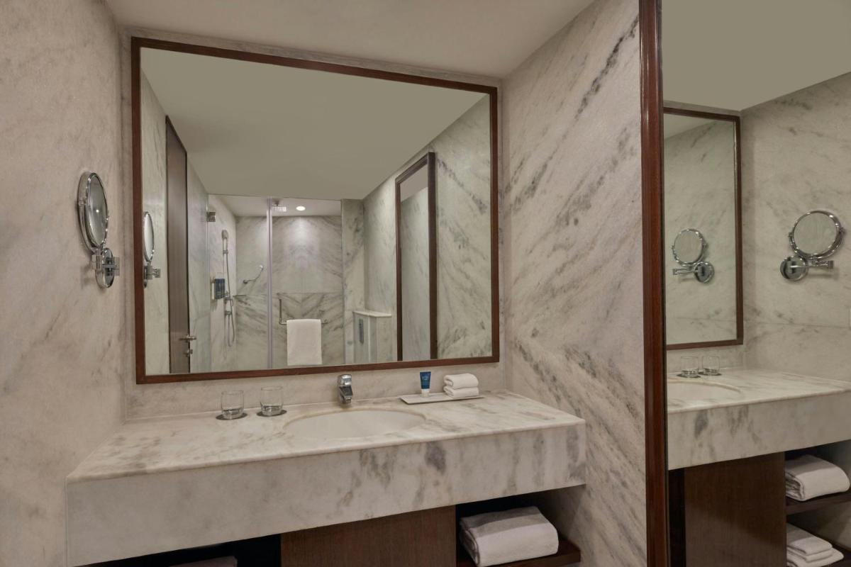 a bathroom with two sinks and a large mirror at Four Points by Sheraton Hotel and Serviced Apartments Pune in Pune