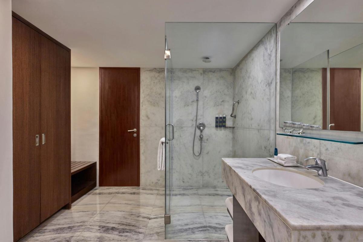 a bathroom with a sink and a glass shower at Four Points by Sheraton Hotel and Serviced Apartments Pune in Pune