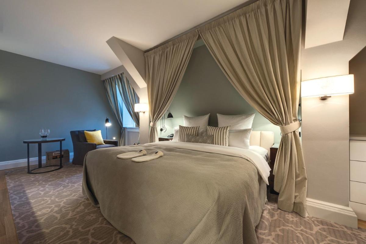 ein Hotelzimmer mit einem großen Bett und Vorhängen in der Unterkunft Weissenhaus Private Nature Luxury Resort in Weißenhaus + 78 Fotos