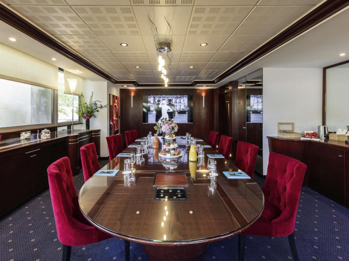 une salle de conférence avec une longue table et des chaises rouges dans l'établissement Sofitel Lyon Bellecour, à Lyon