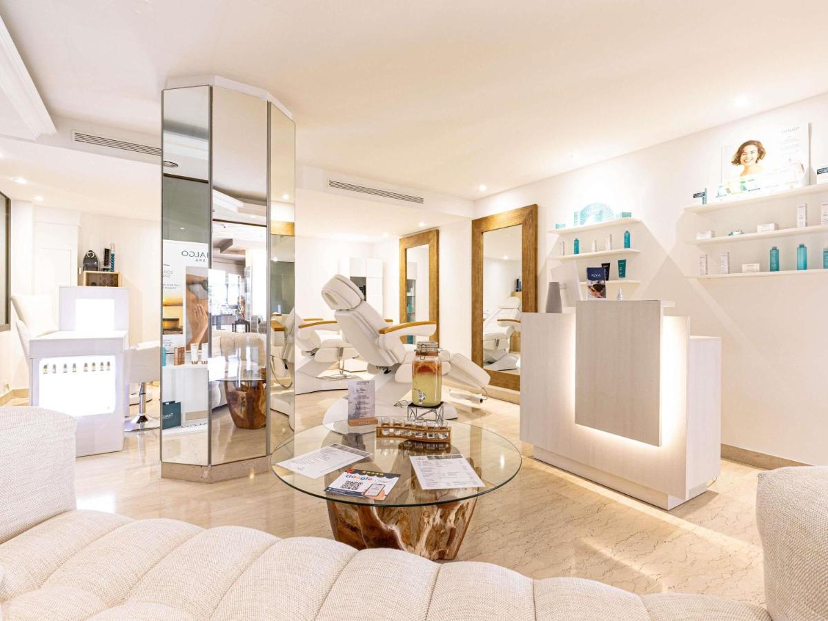 un salon avec un canapé et une table en verre dans l'établissement Pullman Cannes Mandelieu, à Mandelieu-la-Napoule