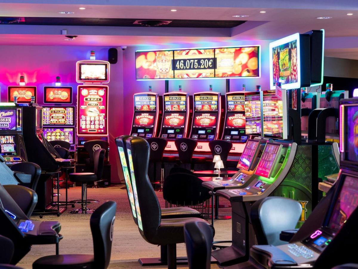 un casino avec de nombreuses machines à sous dans l'établissement Pullman Cannes Mandelieu, à Mandelieu-la-Napoule