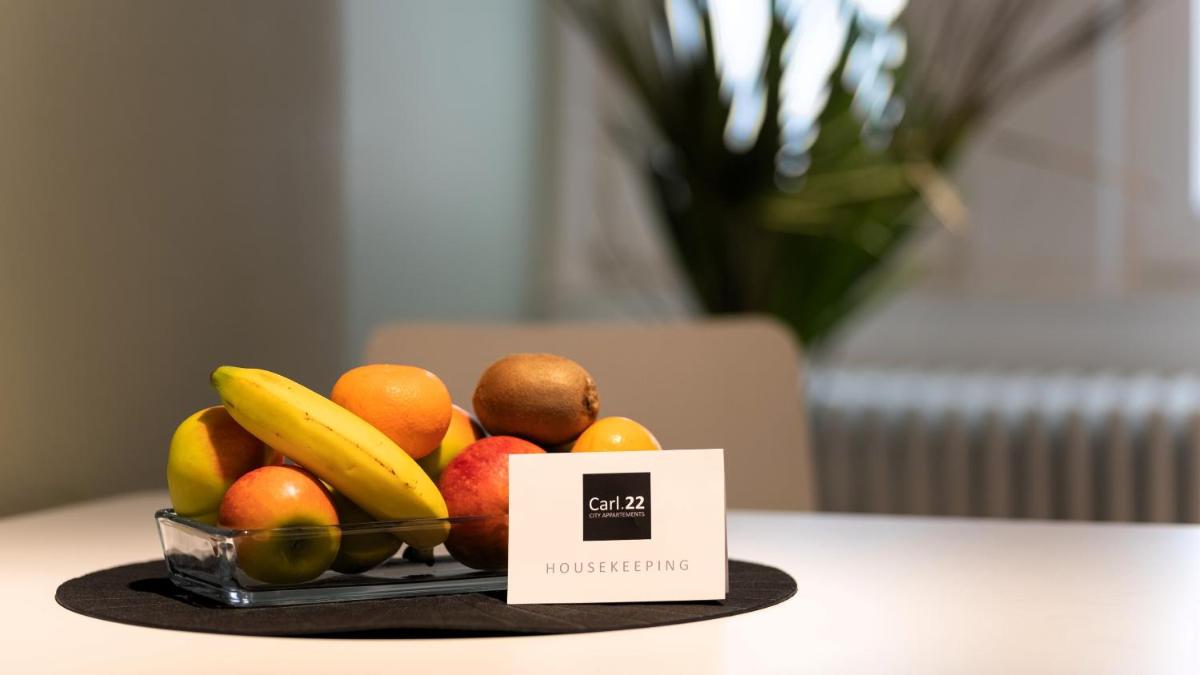 eine Schale Obst auf einem Tisch mit einem Schild in der Unterkunft Carl.22 City Appartements in Eisenach