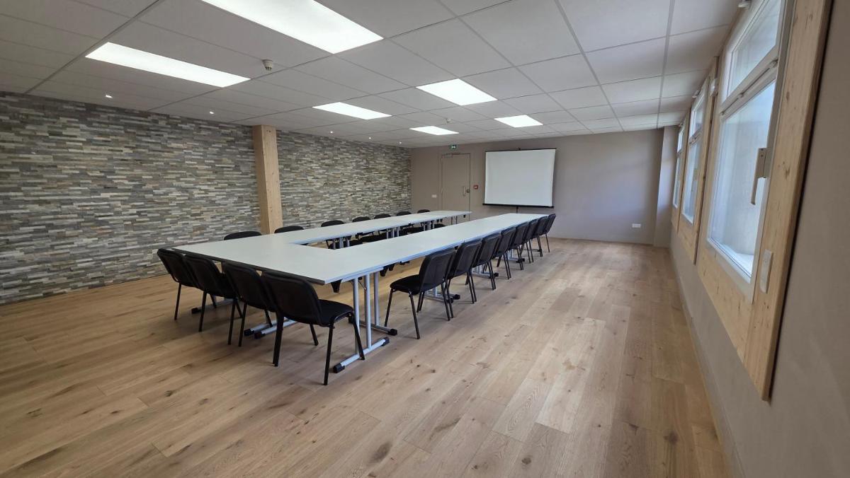 une salle de conférence avec une longue table et des chaises dans l'établissement Hotel Turan & Spa, à Les Deux Alpes